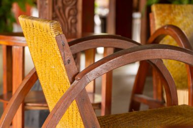 Klasik bir dizaynla ahşap ve rattan yapılmış bir sandalye. Kahverengi boyayla bitiriliyor. İç mekan için bir sandalye örneği.