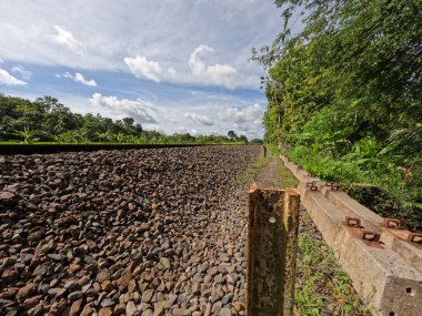 Yogyakarta Endonezya 'daki demiryolu manzarası, görünür kayalar ve temiz bir gökyüzü arkaplanı.