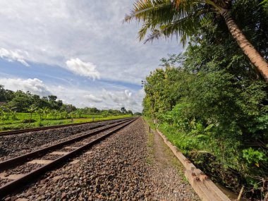 Yogyakarta Endonezya 'daki demiryolu manzarası, görünür kayalar ve temiz bir gökyüzü arkaplanı.