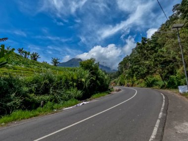 Dağlık bölgelerdeki doğal manzara serin hava, açık ve güneşli gökyüzü sakin yol koşulları ve yeşil bitkiler temiz hava sağlıyor.