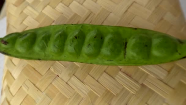 新鮮な野菜や料理のスパイスのために 織り竹のベースに配置された1つの緑の苦い豆棒 — ストック動画