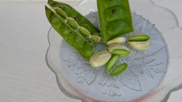 顶部的苦豆块是绿色的 种子已经剥皮 放在一个小玻璃板上 用于新鲜蔬菜或烹调调味品 — 图库视频影像