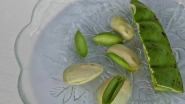 顶部的苦豆块是绿色的 种子已经剥皮 放在一个小玻璃板上 用于新鲜蔬菜或烹调调味品 — 图库视频影像
