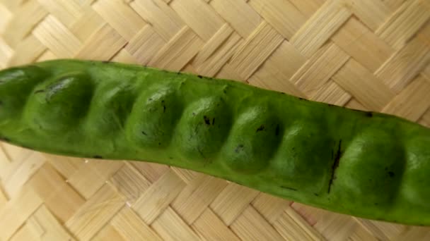 新鮮な野菜や料理のスパイスのために 織り竹のベースに配置された1つの緑の苦い豆棒 — ストック動画