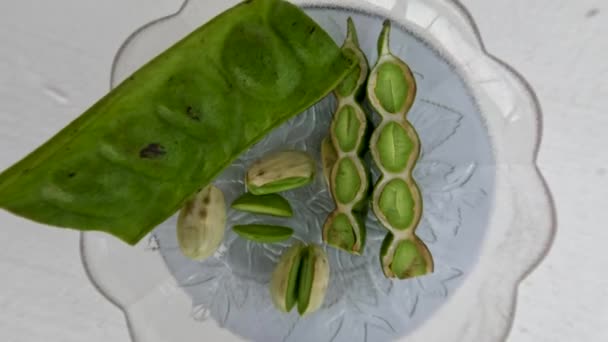 上からの眺めビタービーンズの部分は緑色で 種は皮をむき 小さなガラス板の上に置かれ 新鮮な野菜や料理のスパイスに使われます — ストック動画
