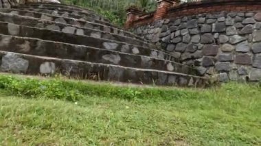 Çimento ve nehir taşı karışımından merdivenlerde kamera hareketi, eğimli hatları olan parktaki binalar.