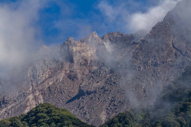 Hafif sisle kaplı Merapi Dağı kraterinin yakınında, bu krater lav püskürtmek ve sıcak bulutlar yaymak için oldukça aktiftir.