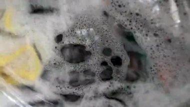 Çamaşırların hareketi ön yükleme tipi çamaşır makinesiyle yıkanmış. Ön kısmı şeffaf camdan yapılmış. Böylece içerideki süreci görebiliyoruz.