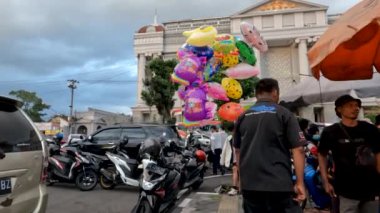 Yogyakarta, Indonesia - August 17, 2022. Balloon traders let their wares sway here and there to attract attention, peddling their wares in places that are the center of community activity
