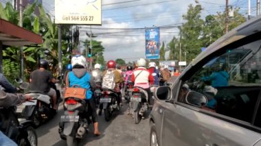 Yogyakarta, Indonesia - August 25, 2022. Traffic situation at the Denggung-Sleman traffic light at noon during working hours, Area around the Sleman Regency Regional Government complex