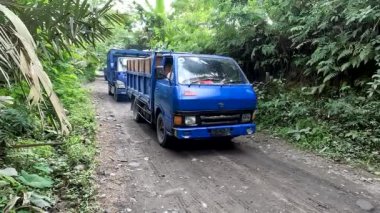 Magelang, Indonesia - August 30, 2022. A convoy of trucks transporting sand and stones from a volcanic river in the Srumbung area of Magelang, Central Java. Mining of sand and stone for infrastructure needs in Central Java and Yogyakarta