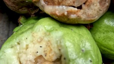 A pile of crystal guava that is rotten due to fruit fly attacks, the inside of the fruit is filled with larvae, the rotten fruit becomes inedible