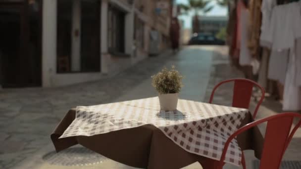 リゾートタウンのカフェの空のテラス 小さなレストランの孤独な空のテーブル 大流行での小規模なビジネス — ストック動画