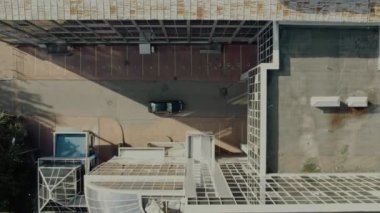 car rides under buildings view from above and past the cars on the road