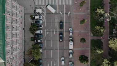 two black cars are waiting for a white car to turn and then they go straight ahead, fly over city street and cars
