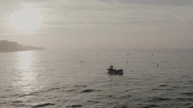 fishing boat in the sea rocks in the background