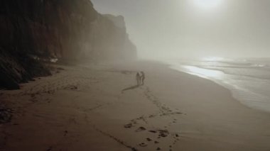 a married couple with a child is driving along the seashore footprints in the sand