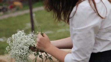 decorating with white flowers in hands close-up