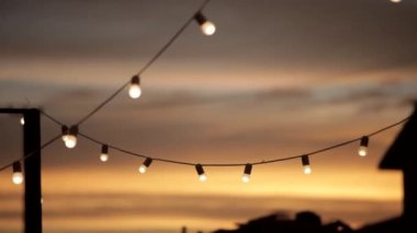 garland of light bulbs at sunset glow