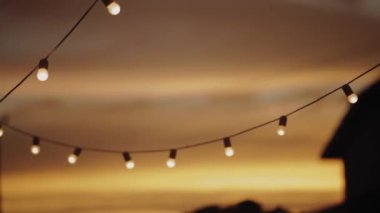 garland of light bulbs at sunset glow