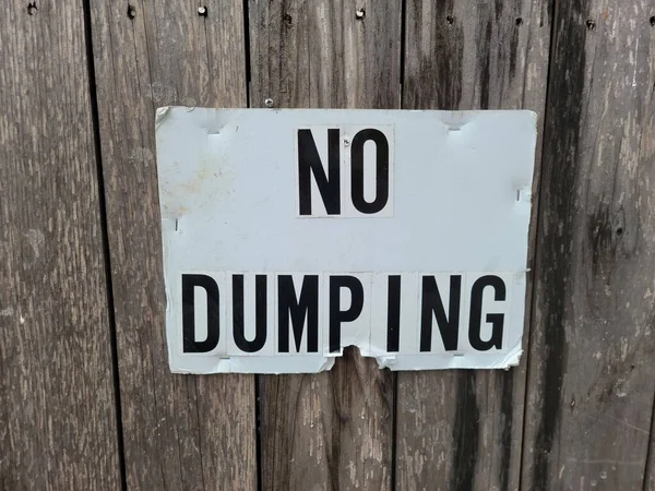 Dumping Sign Hangs Textured Wooden Fence — Stockfoto