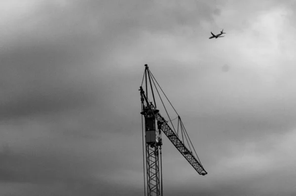 飛行機の風景で空に対する高いクレーンの建設 — ストック写真