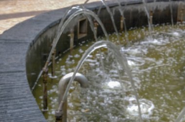 Şehir parkının fıskiyesi suyu yakın plan akıyor.