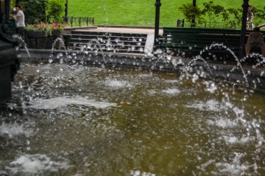 Şehir parkının fıskiyesi suyu yakın plan akıyor.