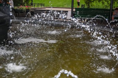 Şehir parkının fıskiyesi suyu yakın plan akıyor.