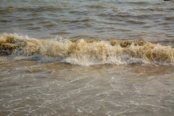Güneşli sahilde kara deniz dalgaları