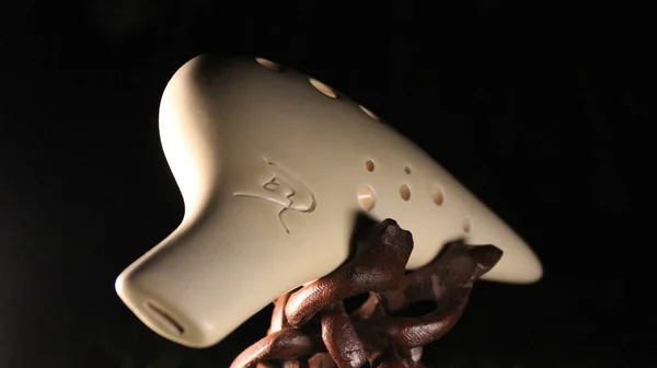 White ceramic ocarina at night