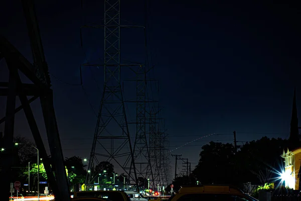 Gece gökyüzü elektrik kulelerinin yanında
