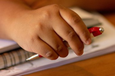 Kırmızı kalem tutan biri.