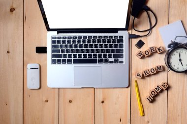 Evde çalışmak için beyaz boş ekrana taşınabilir bilgisayar dizüstü bilgisayarı aç, donanım aksesuarları ahşap masaya yerleştirilmiş, ev konsepti, kopyalama alanı, üst görünüm