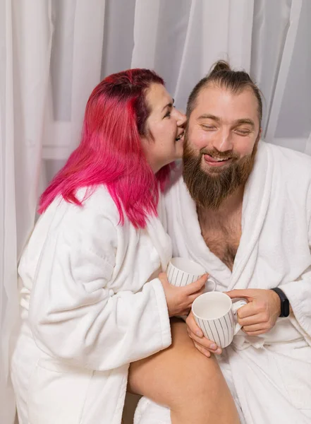 Beyaz önlüklü bir aile. Karı koca öpmeye çalışıyor.