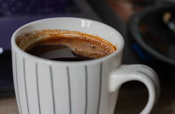 Top view of white coffee cup on dark background