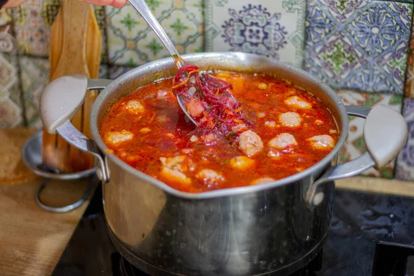 Borsch is a traditional Ukrainian Russian hot soup cooked in a large metal pot. Beets, cabbage, carrots, potatoes, peppers, onions, tomatoes are boiled in meat or vegan broth. Ukrainian food