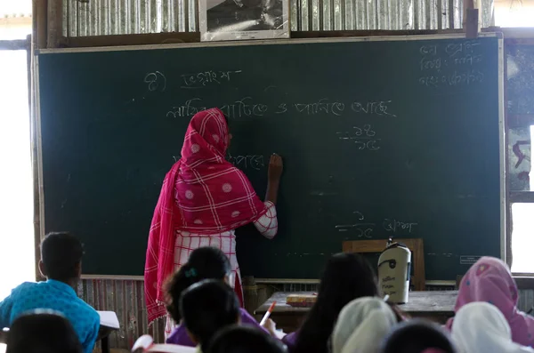 Gowainghat, Bangladeş - Kasım 06, 2019: Kırsal ya da uzak okullardan gelen öğretmen öğrencilere matematik öğreterek öğrencilerin denklemlerini kara tahtaya yazarak.