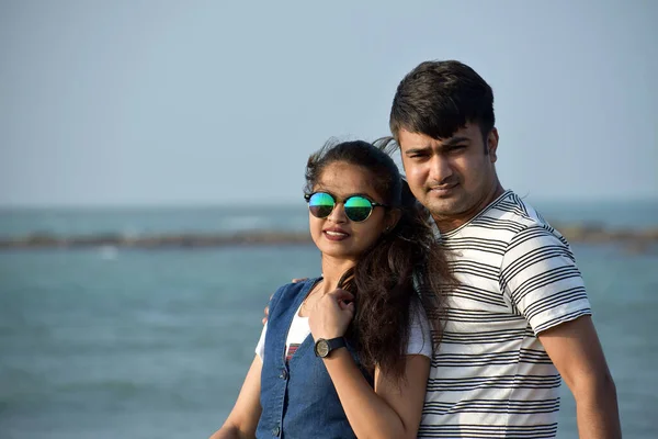 Portrait of a young couple on the sea beach enjoying honeymoon time. Closeup of a beautiful woman leaning on her boyfriend.