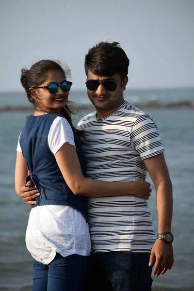Young couple hugging and holding each other in the sea background. Man and woman made for each other and love forever concept.