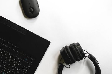 Laptop, fare, büyük siyah kulaklıklar beyaz arkaplan üzerinde metin için bir yer, üst görünüm