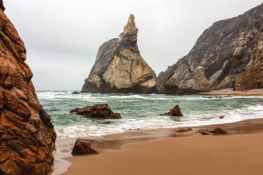 Kayalar ve kayalıklar arasında azgın suların olduğu sahil manzarası