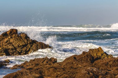 Öfkeli Atlantik Okyanusu 'nun güzel sabah manzarası. Mavi su, köpük dalgaları, sıçramalar ve açık gökyüzü ile Portekiz.
