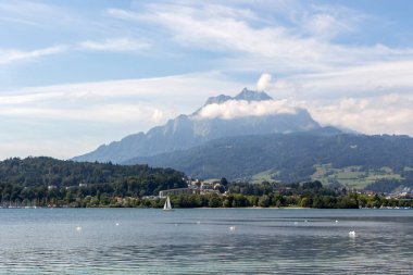 Pilatus Dağı ve gölde kuğuları olan bir yat.