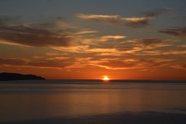 Güneş, Fuerteventura 'daki Costa Calma Körfezi' nin üzerinde kısmen bulutlu gökyüzü olan Kanarya Adaları 'nda yükseliyor.