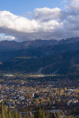 Güzel desenli bulutları olan sonbahar dağları. Güneşli bir gün. Sarı ağaçlar. Kozalaklı orman.