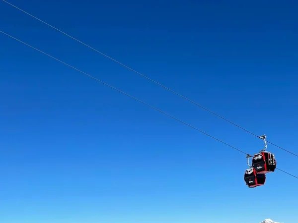 冬のスキー場の青い空に対する赤いゴンドラと雪｜Golm, Montafon, Austria, 12.12.2021. — ストック写真