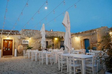 Marzamemi, İtalya, 29.03.2018. Geceleri dolunaylı büyüleyici restoranda güzel bir açık hava oturma yeri..