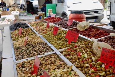 Sciacca, Sicilya, İtalya, 24.03.2018. Sciacca, Sicilya, İtalya 'daki market standında siyah ve yeşil zeytin, kurutulmuş domates ve turşu çeşitleri..