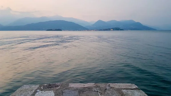 Laituri Stresan rannalla auringonlaskun aikaan. Henkeäsalpaavat näkymät Lago Maggiore, Piemonte, Italia. — kuvapankkivalokuva